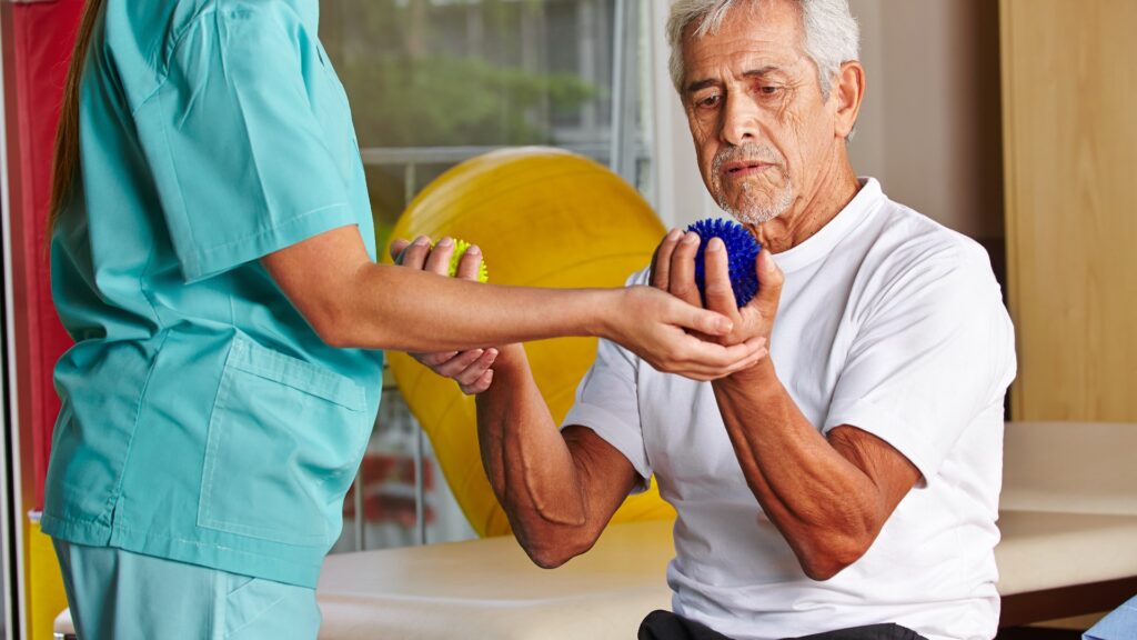 Senior mit Igelball bei Physiotherapie