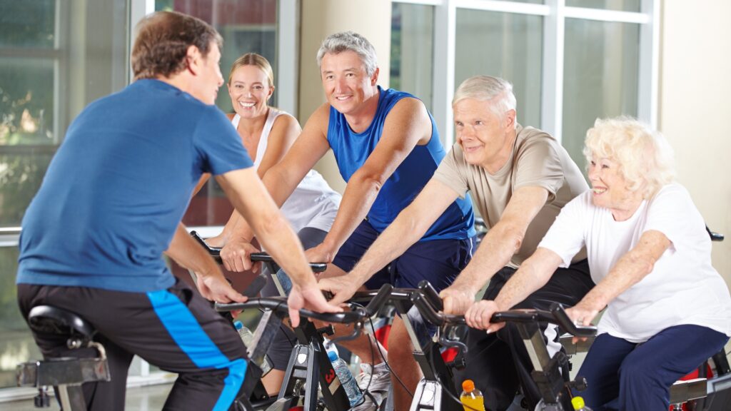 Trainer mit Gruppe Senioren beim Spinning
